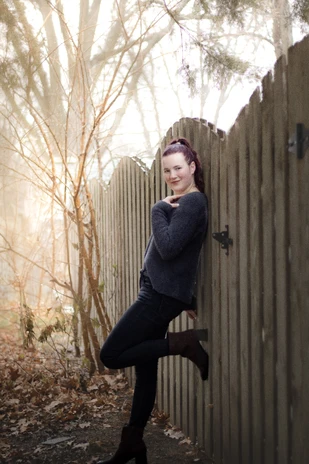 A young girl smiling during her senior photos, taken by an Omaha wedding photographer