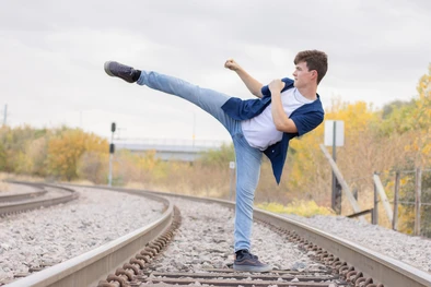 A young man doing a taekwondo kick during his senior photos in Omaha, NE